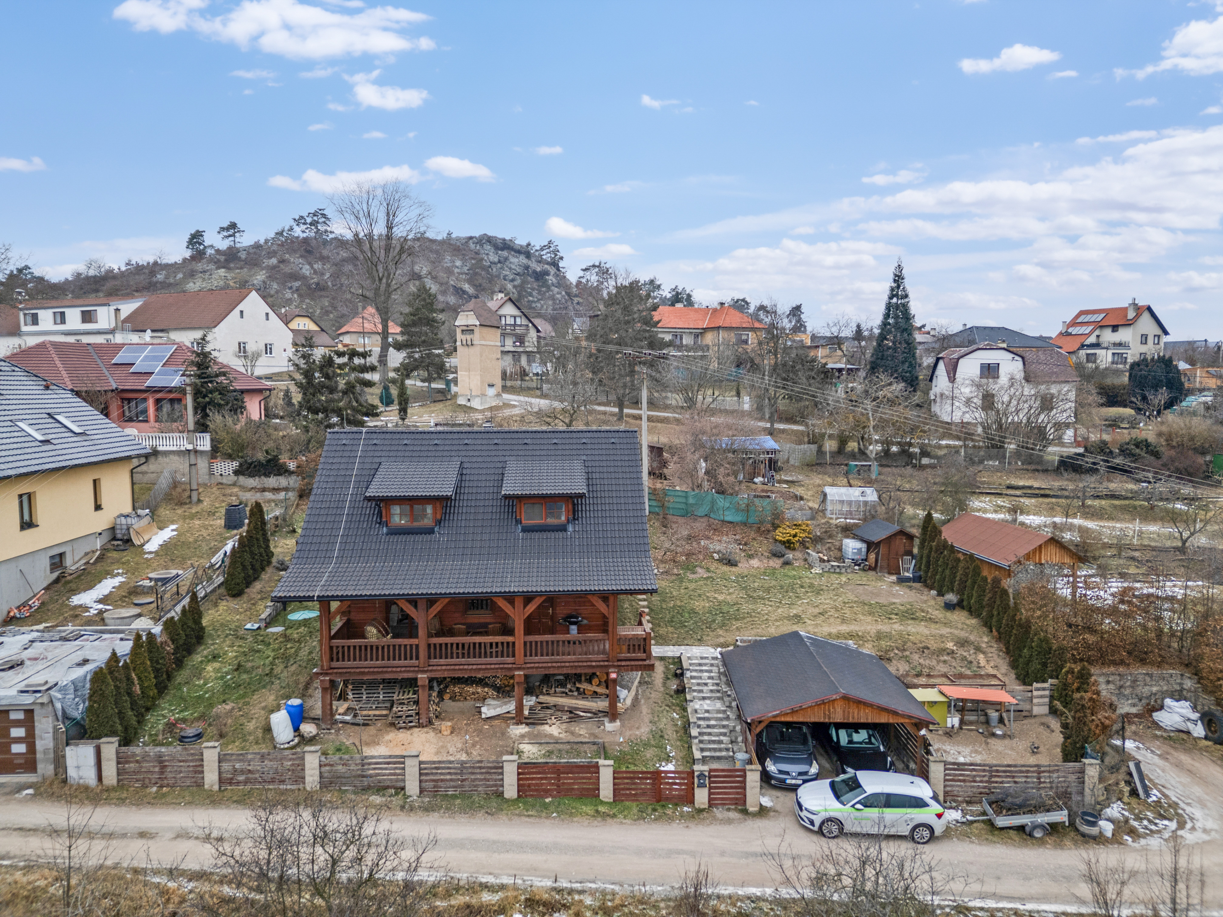 Dům se zahradou a otevřeným krytým stáním pro auta